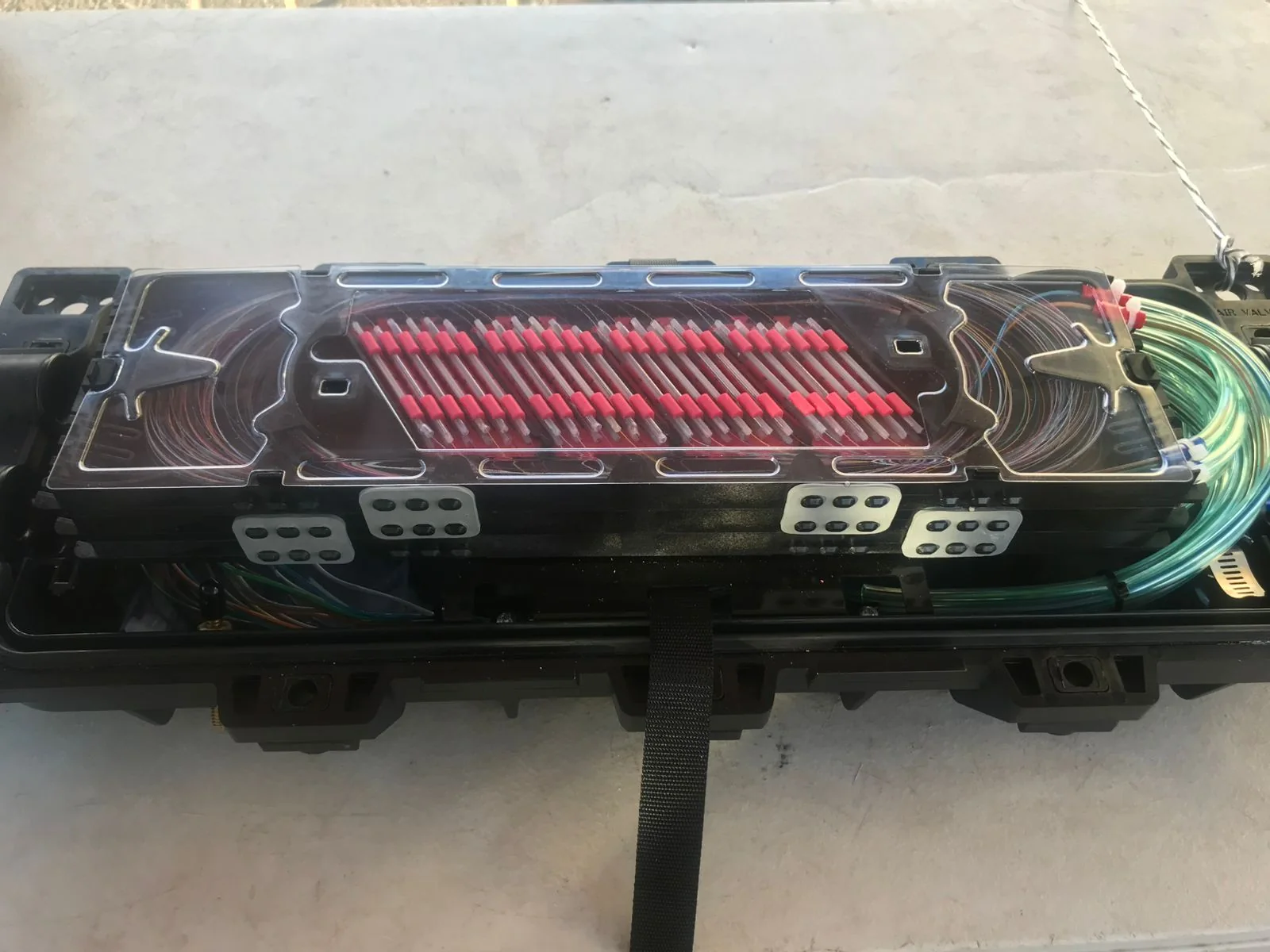 Top view of a fiber splice closure with a transparent protective cover.