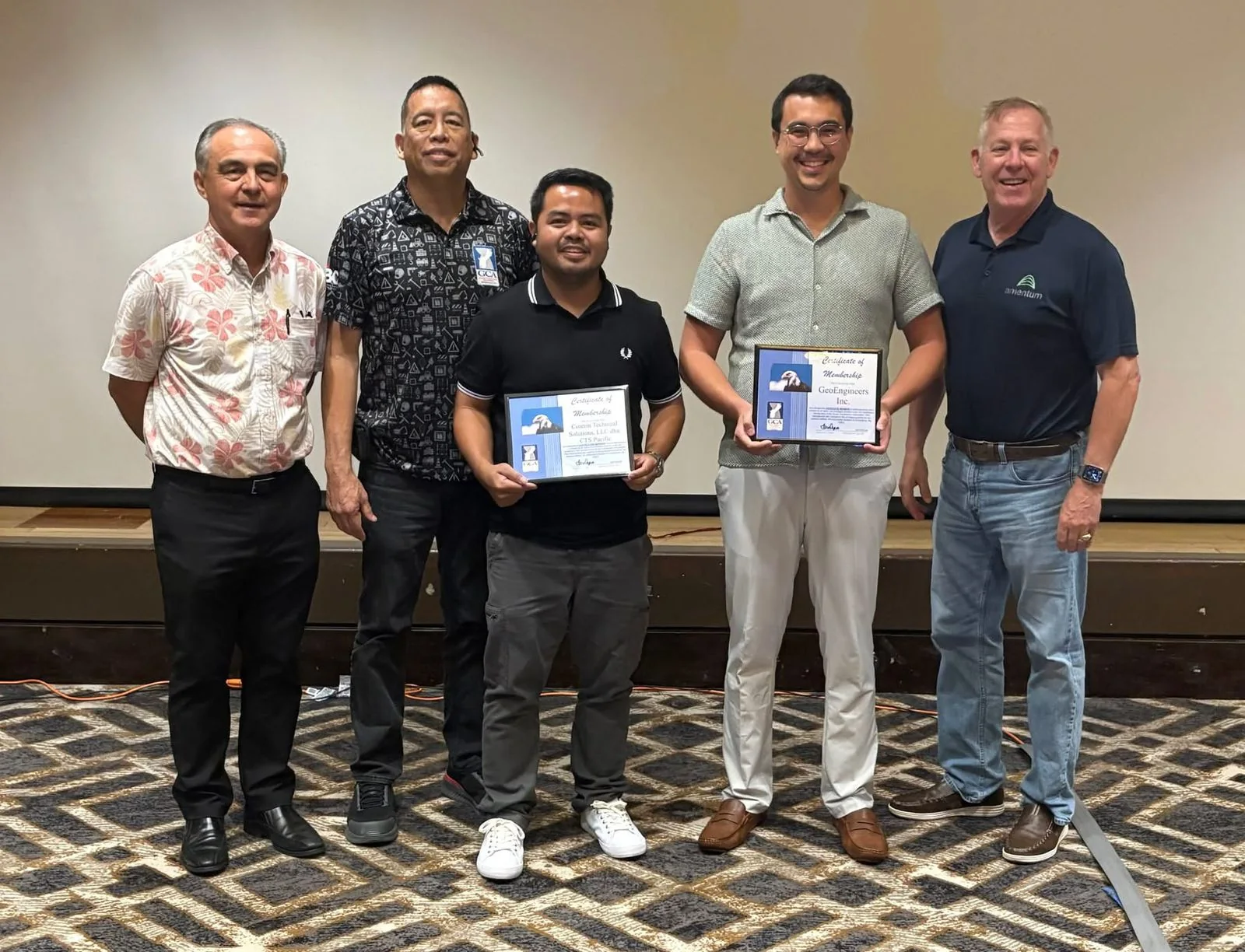 Group holding Guam Contractors Association membership certificates, including the CTS Pacific certificate.
