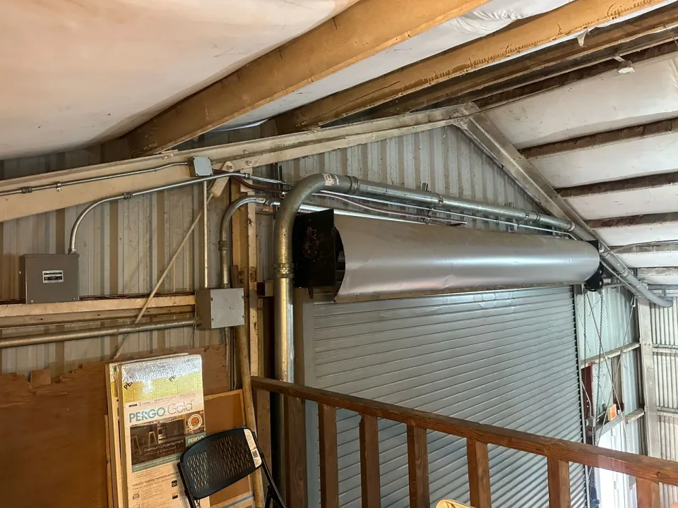 Metal conduit routed above a warehouse roll-up door.