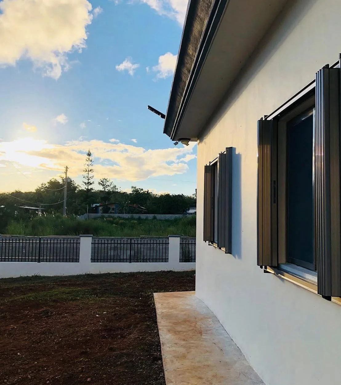 Exterior surveillance camera mounted beneath the roofline of a white residential building.