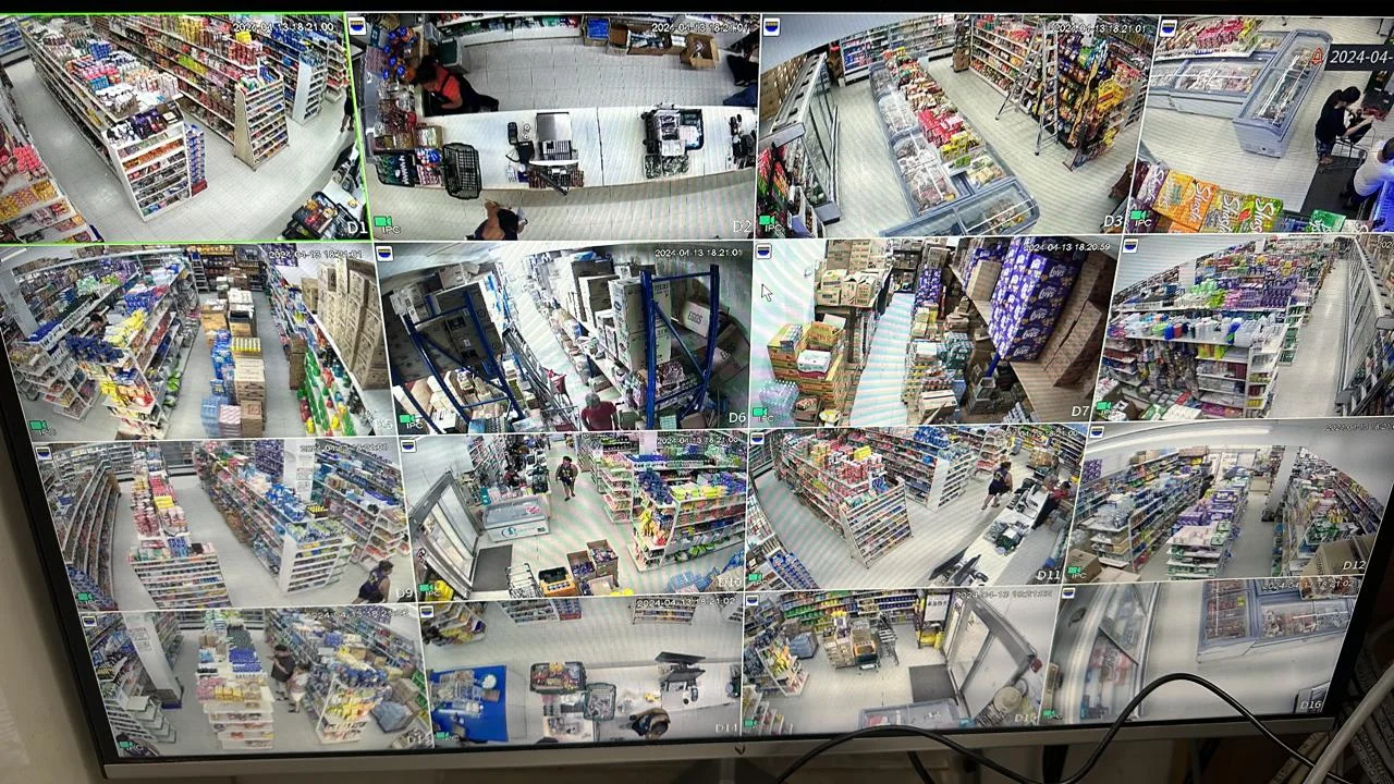 Surveillance monitor showing a grid of camera views across retail aisles, counters, and entrances.