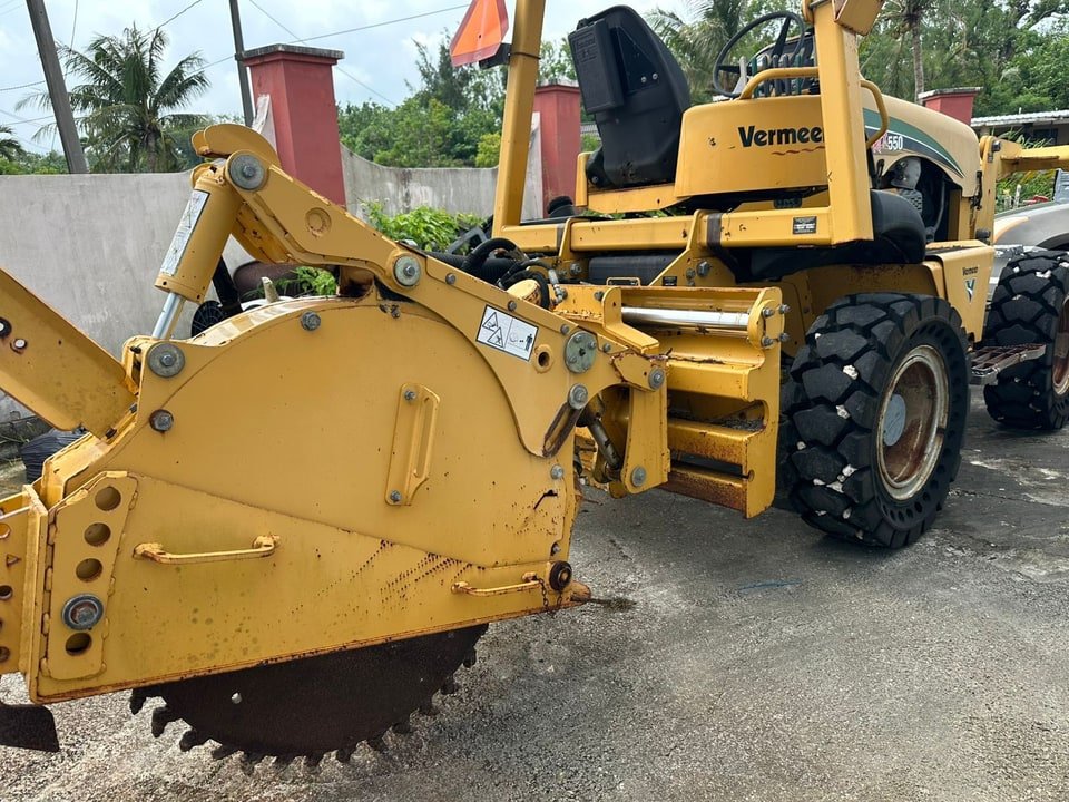 Client-supplied Vermeer equipment with a large cutting-wheel attachment on a paved surface.