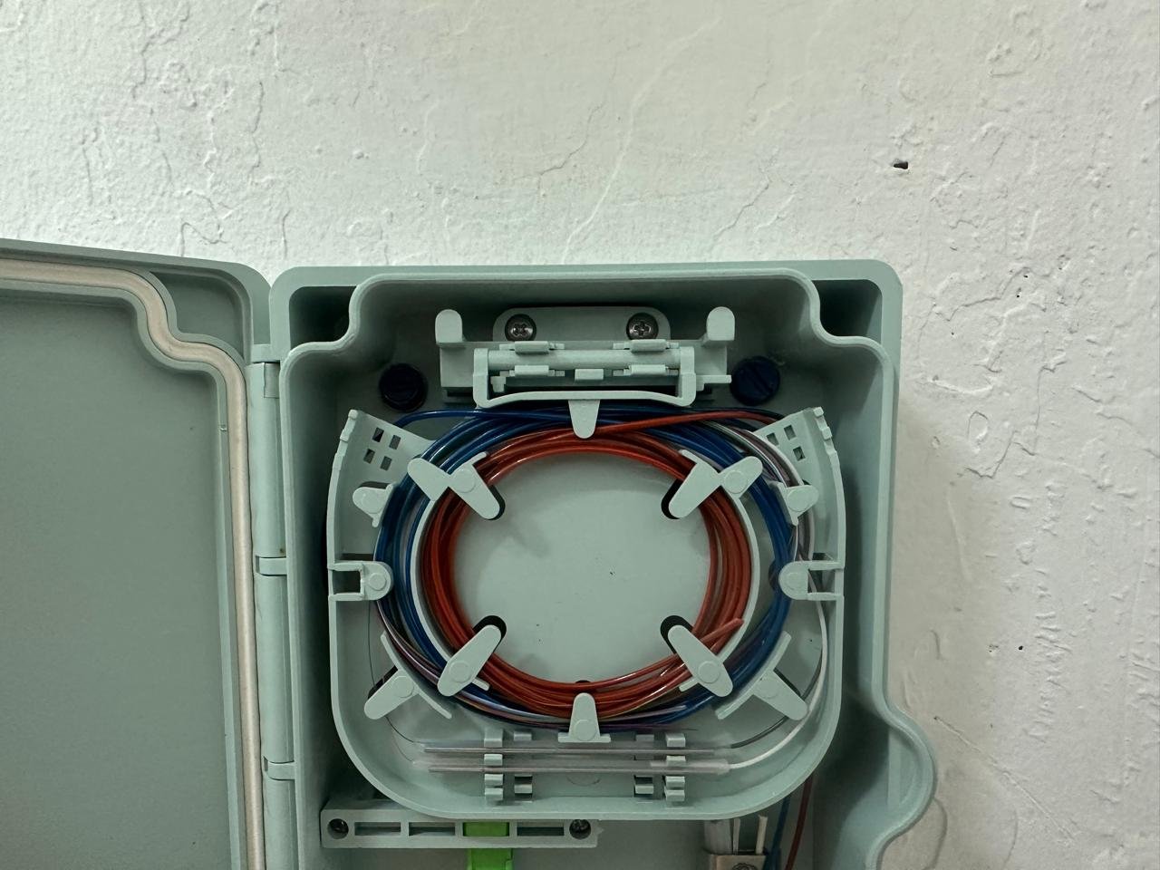 Open fiber enclosure showing organized fiber loops during CTS Pacific field work.
