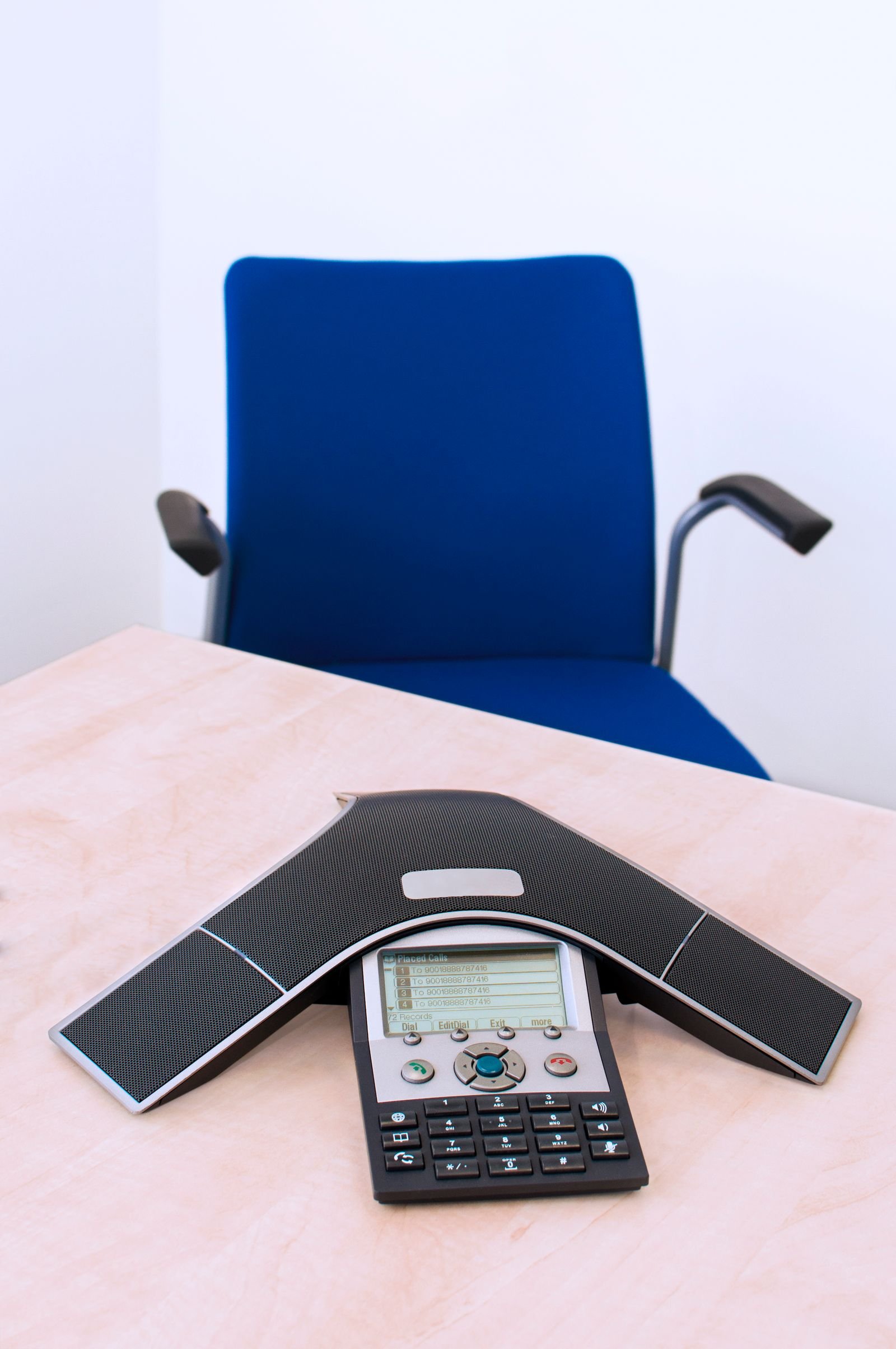 Conference telephone installed in a professional meeting space.